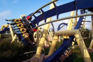 Thrill-seekers riding Montu, an inverted roller coaster, included when you buy Busch Gardens Florida tickets. With its intense loops and high-speed turns against a bright blue sky.