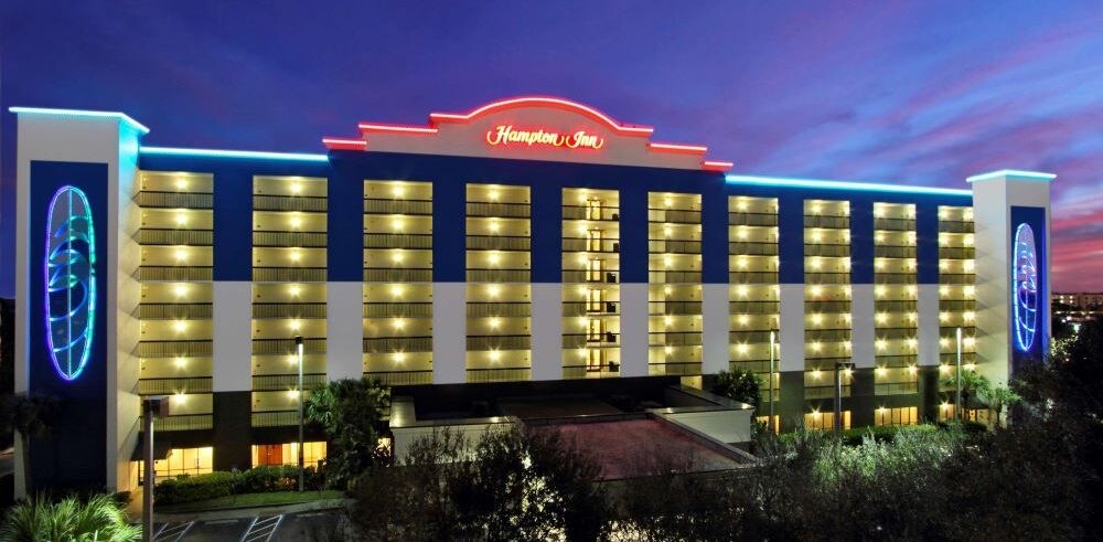 Hampton Inn Cocoa Beach hotel lit up at night.