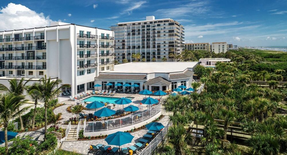 Exterior view of Hilton Garden Inn, a Cocoa Beach dog friendly hotel, featuring lush grounds and accommodations for guests traveling with pets.