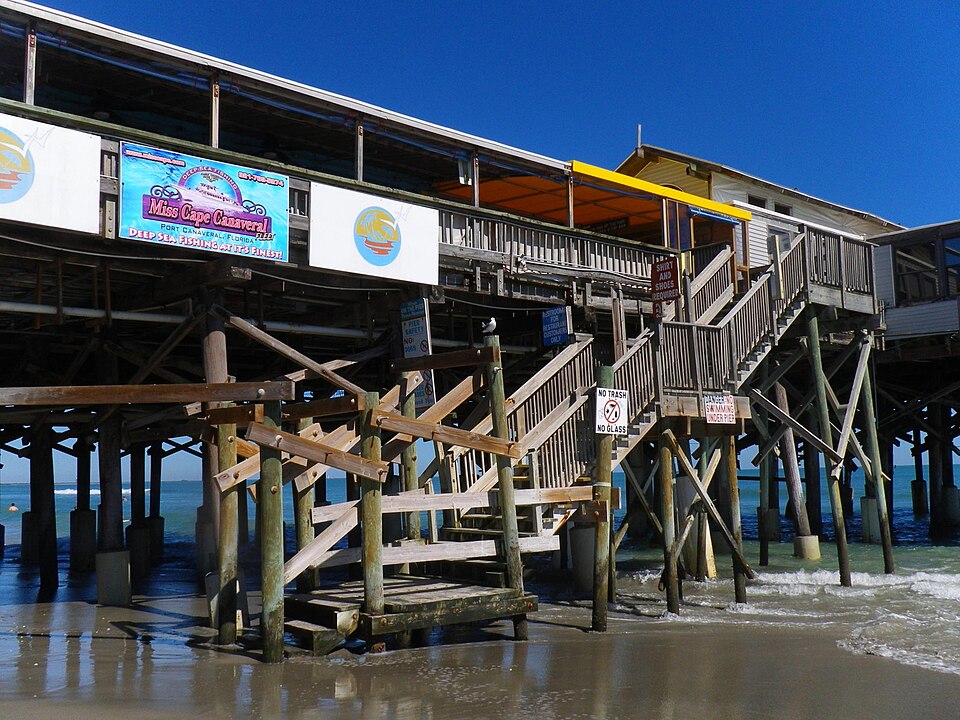 Cocoa Beach Pier extending over the Atlantic Ocean with wooden stairs leading to oceanfront dining and entertainment.