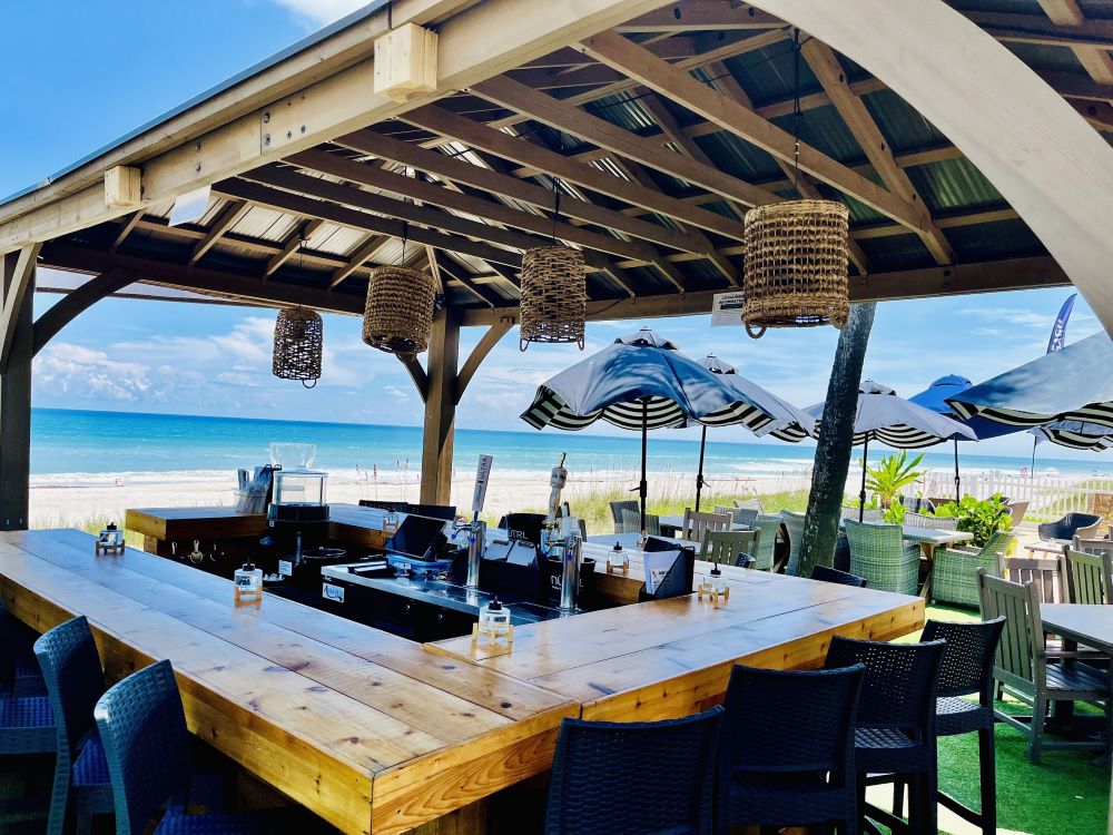 Open-air bar area at Bleu Beach Resort with a wooden table