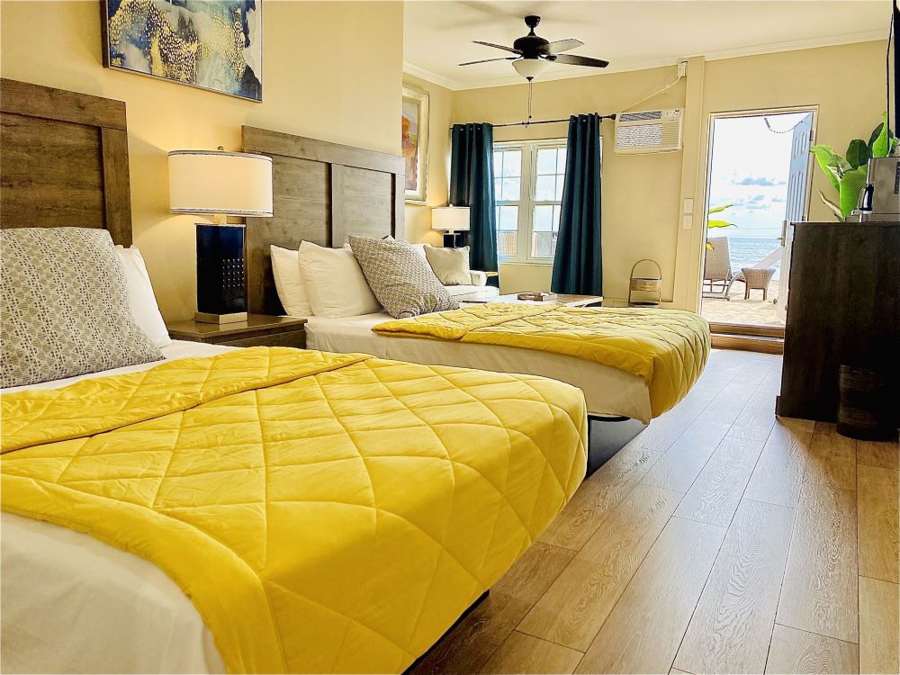 Cozy hotel room at Bleu Beach Resort with twin beds and yellow blankets.