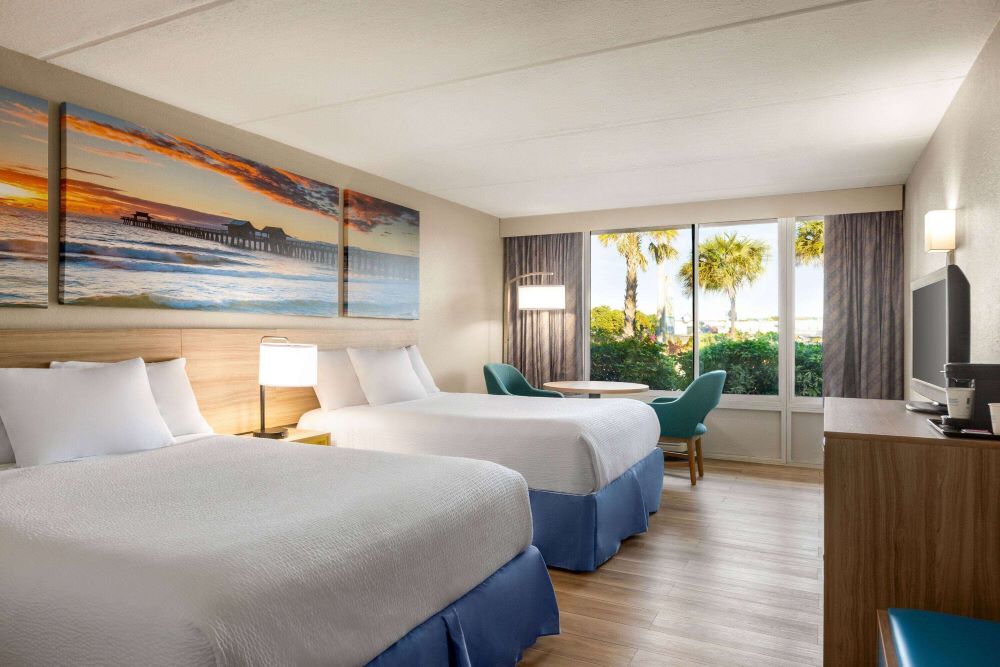 A spacious guest room at Days Inn by Wyndham Cocoa Beach, Florida, offering comfortable accommodations near Cocoa Beach Florida beachfront hotels and attractions.