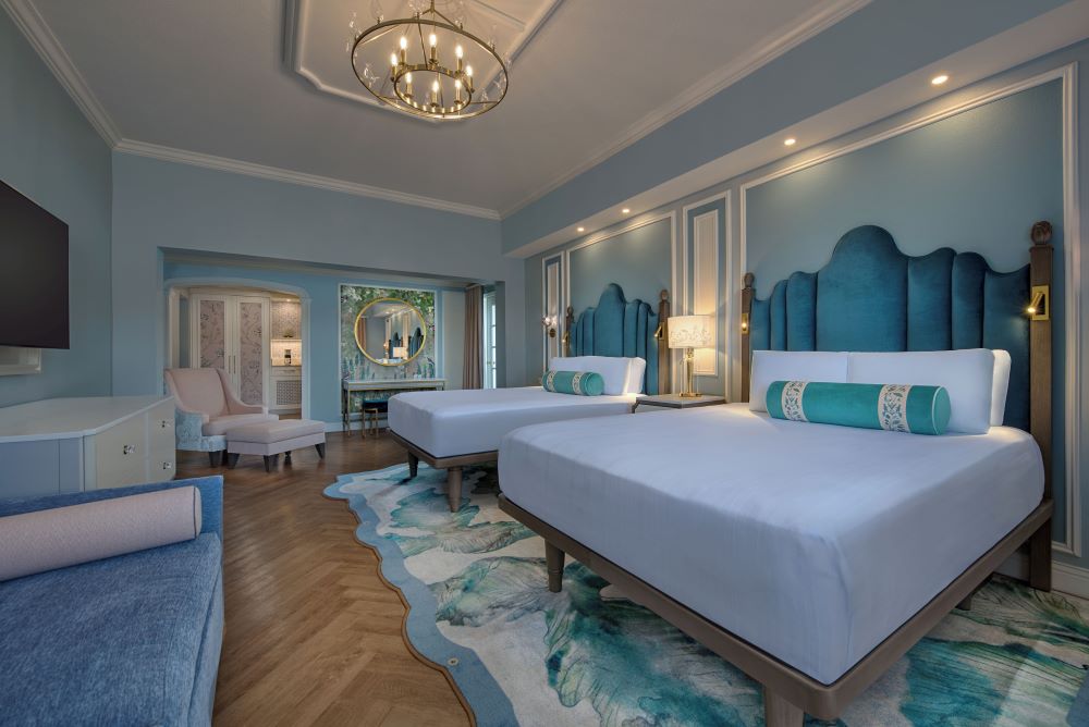 View of guest room at Disney Grand Floridian hotel shows two queen beds with luxury bedding.