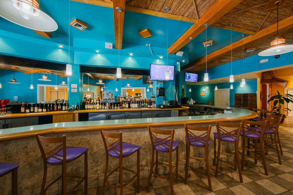 a bar with chairs and a row of lights at the Holiday Inn Club Vacations Cape Canaveral Beach Resort, a favorite on the list of great beach resorts in Florida.