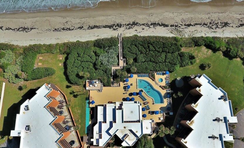 Aerial view of Oceanique Resort with beachfront access and a central pool area.