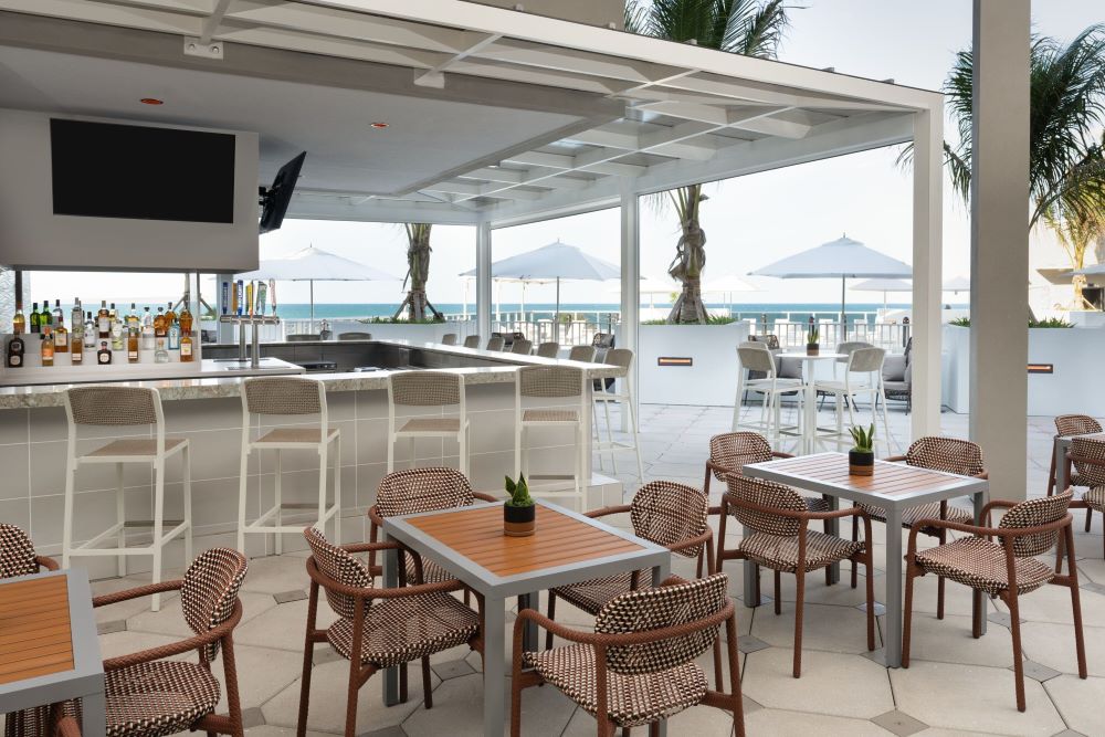 Outdoor bar area with seating overlooking the ocean at Element Melbourne Oceanfront.