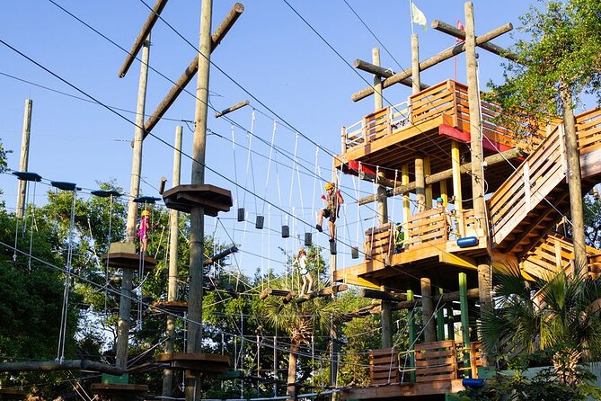 Visitors navigating rope bridges and zip lines at Cocoa Beach Aerial Adventures, a thrilling treetop obstacle course on Florida’s Space Coast.