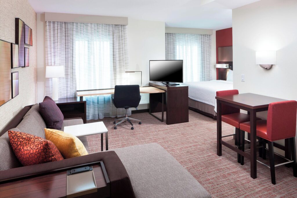 Spacious suite at Residence Inn with kitchen, couch, work desk, and modern lighting